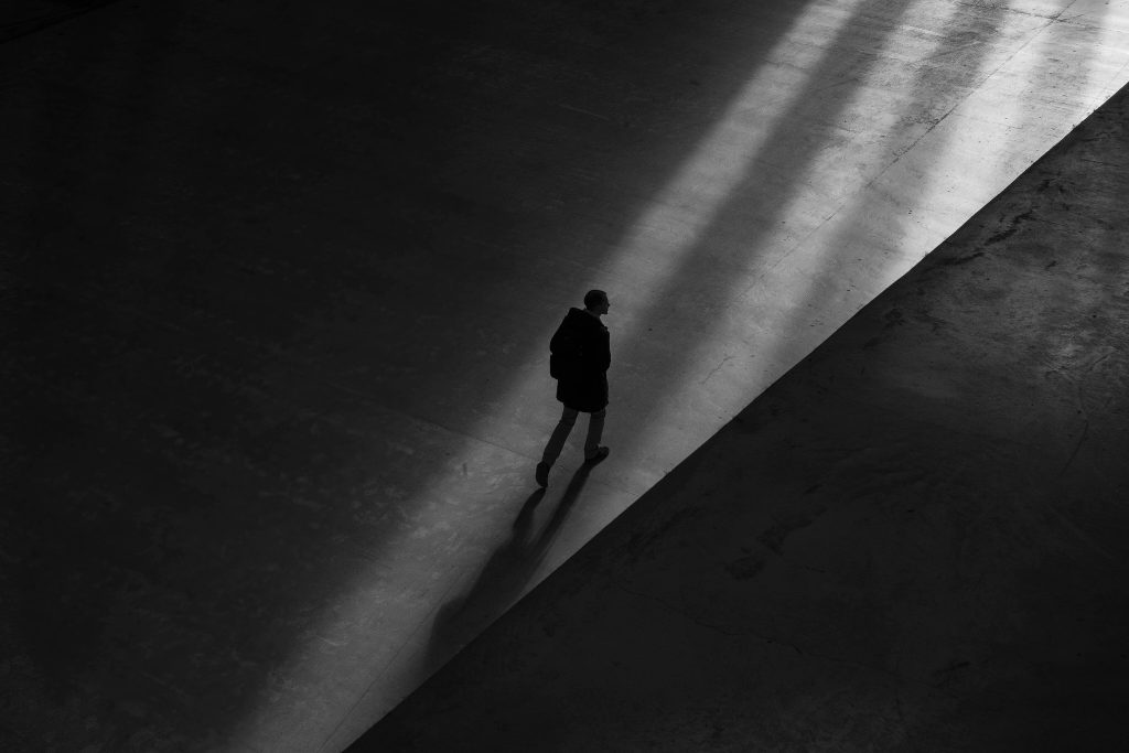 Man walks alone from dark to light after relapse