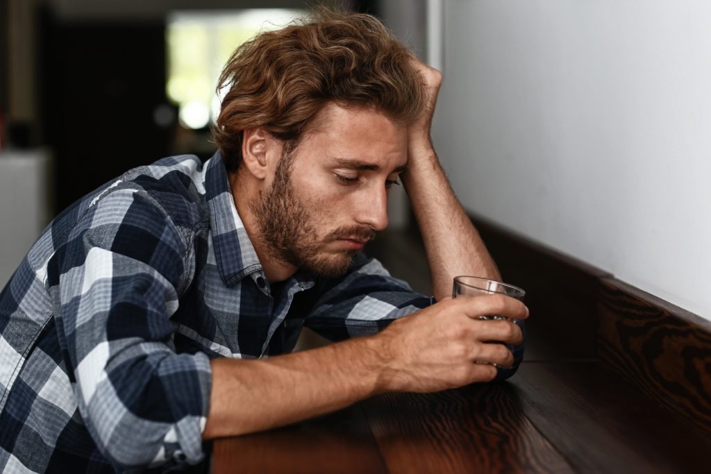 alcoholic young man holding a drink