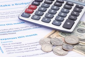 calculator, coins, paper money, and budget worksheets 
